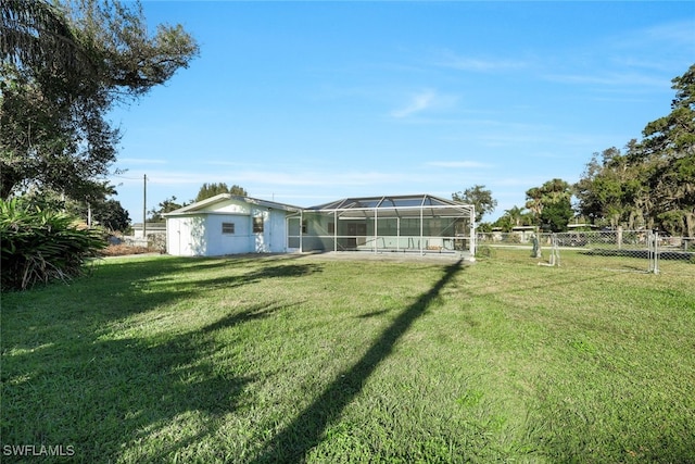 rear view of house featuring a lawn and glass enclosure