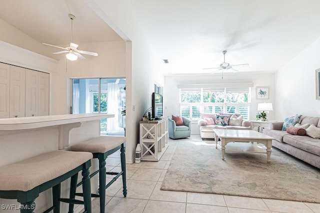 tiled living room featuring ceiling fan and lofted ceiling