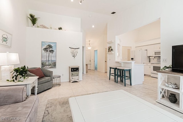 living room with high vaulted ceiling and light tile patterned floors