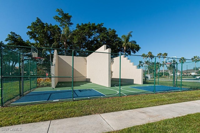 view of basketball court with a yard