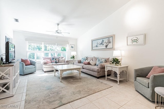 living room with lofted ceiling, ceiling fan, and light tile patterned floors