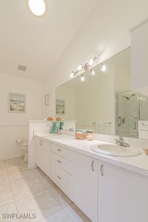 bathroom featuring a shower with door, tile patterned flooring, vanity, and toilet