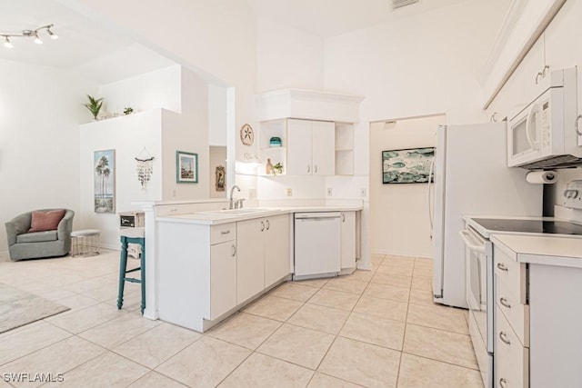 kitchen with white appliances, white cabinetry, light tile patterned flooring, and sink