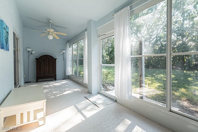 unfurnished sunroom featuring ceiling fan and a wealth of natural light