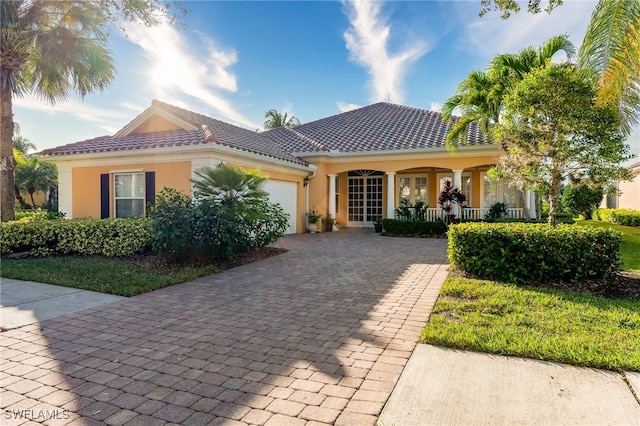 mediterranean / spanish-style home with a porch and a garage