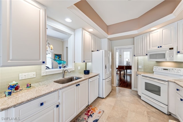 kitchen featuring sink, white cabinets, and white appliances