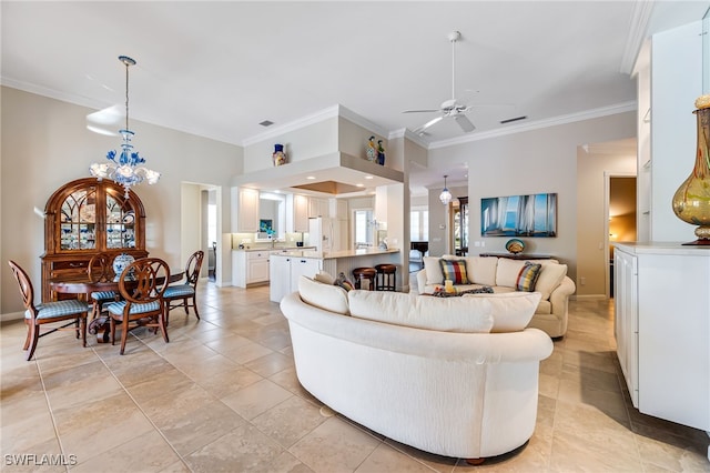 tiled living room with ceiling fan with notable chandelier and crown molding