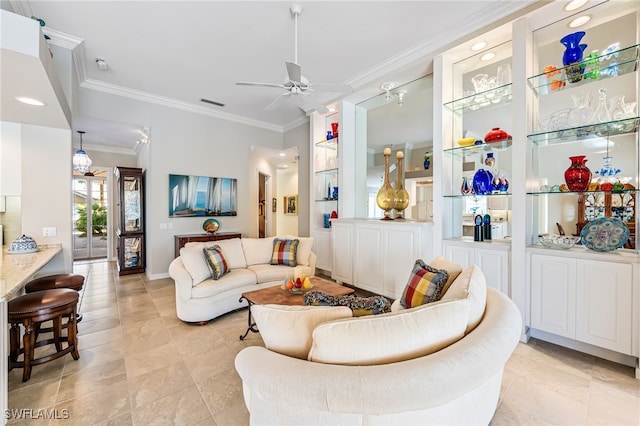 living room featuring ceiling fan, crown molding, and built in shelves