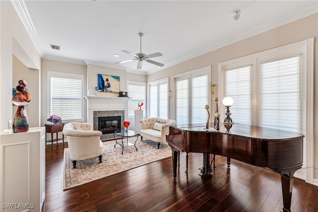 living room featuring ceiling fan, ornamental molding, dark wood-type flooring, and a wealth of natural light