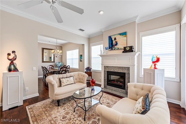 living room with ceiling fan with notable chandelier, ornamental molding, and dark wood-type flooring