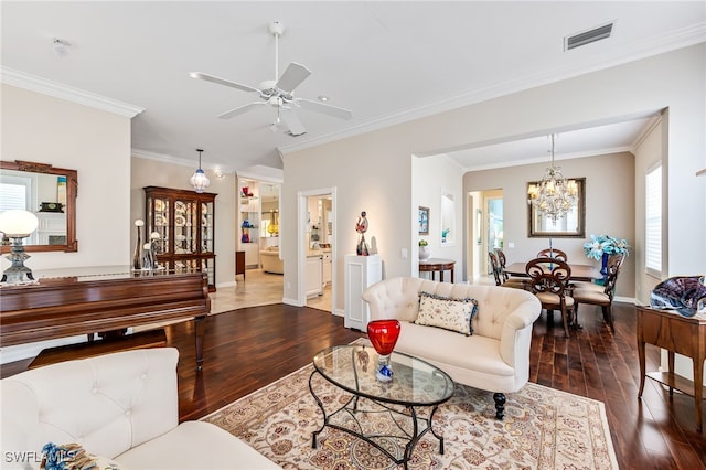 living room featuring ceiling fan with notable chandelier, dark hardwood / wood-style floors, and ornamental molding