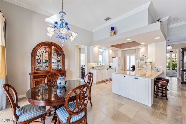 dining space with ornamental molding, a notable chandelier, and sink