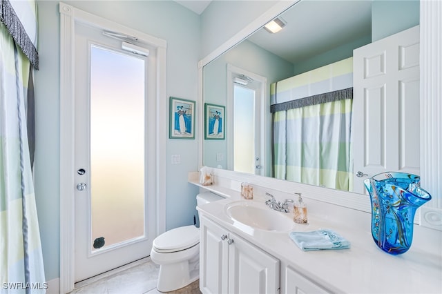 bathroom featuring tile patterned floors, plenty of natural light, vanity, and toilet