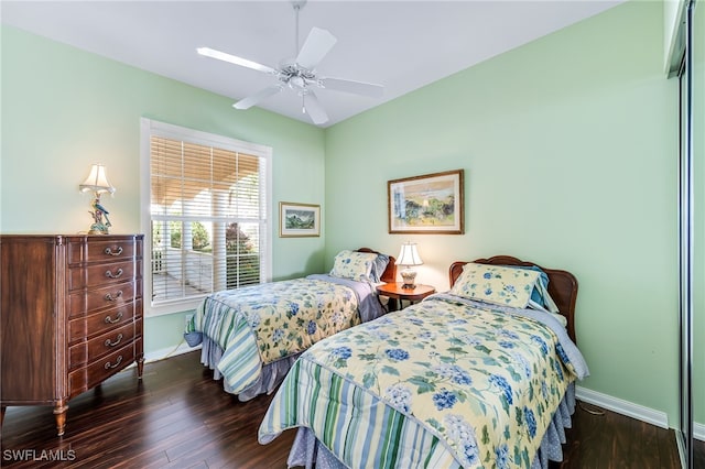 bedroom with dark hardwood / wood-style flooring and ceiling fan