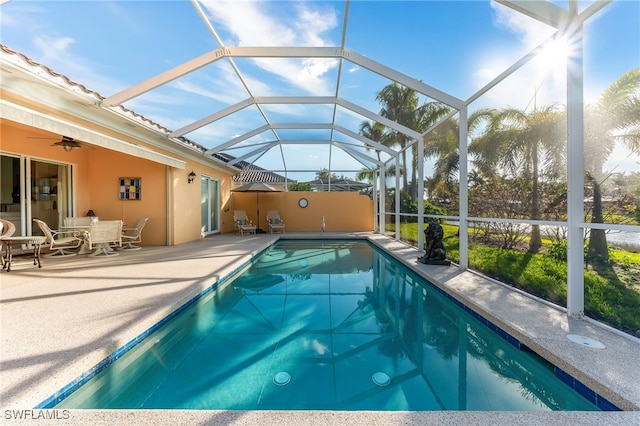 view of pool with glass enclosure and a patio area