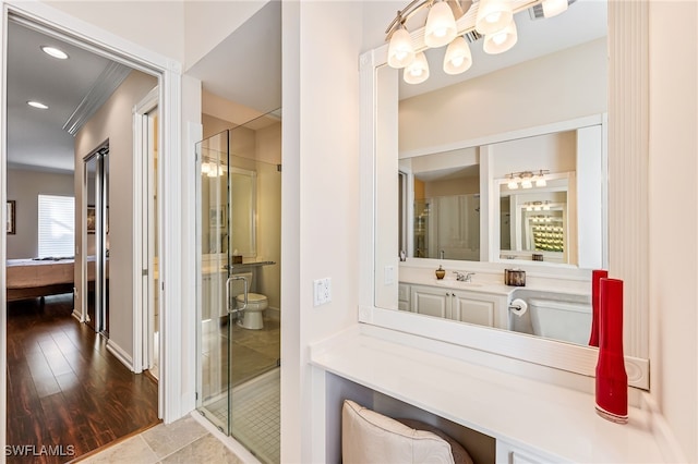 bathroom with an enclosed shower, vanity, and toilet