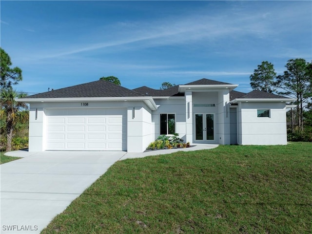 view of front of home featuring french doors, a front yard, and a garage