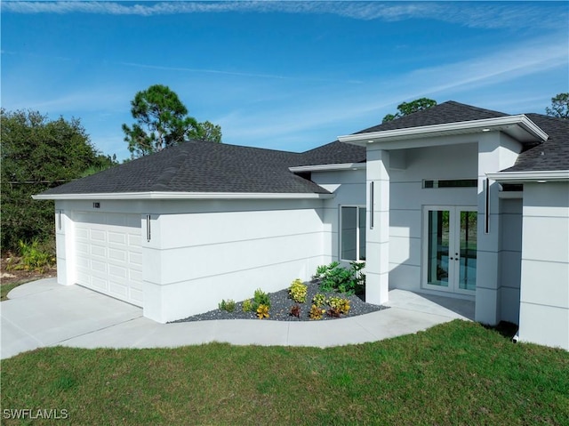 view of front of property with a front lawn, a garage, and french doors