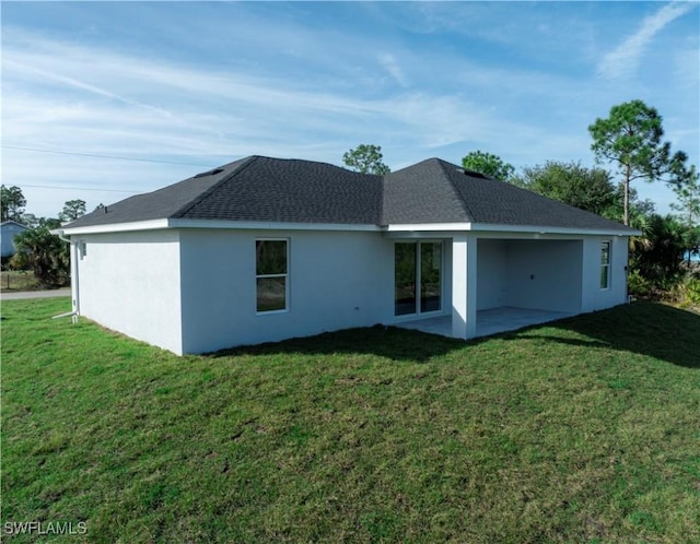 rear view of house featuring a yard and a patio