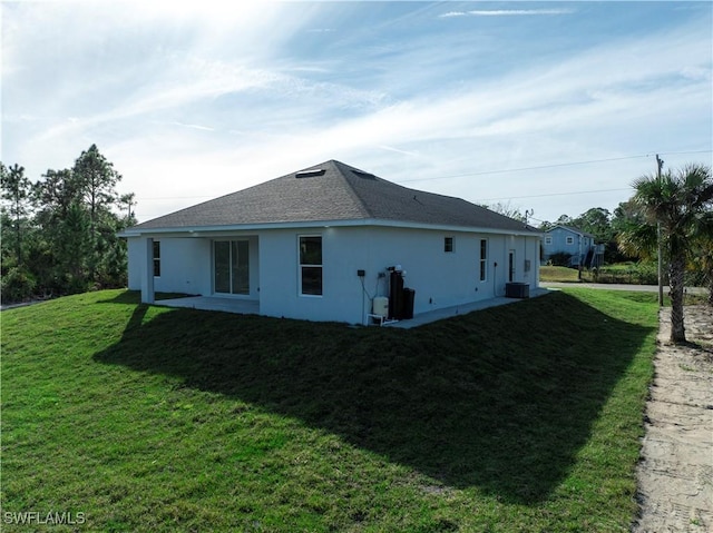 view of side of home with central AC and a lawn