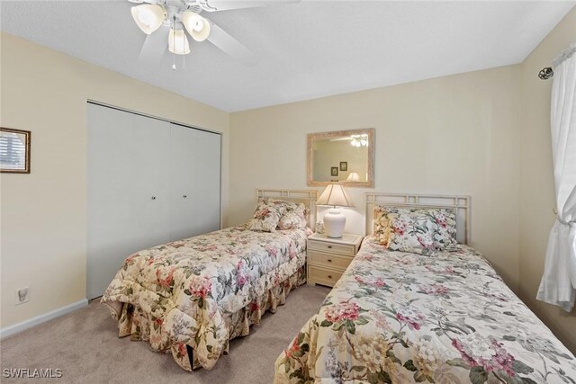 bedroom featuring light colored carpet, a closet, and ceiling fan