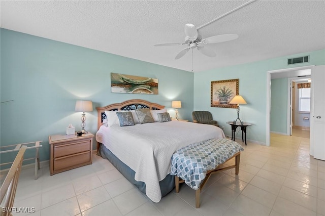 tiled bedroom with ceiling fan and a textured ceiling