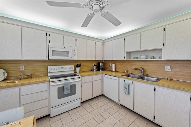 kitchen featuring white cabinetry, sink, light tile patterned flooring, and white appliances