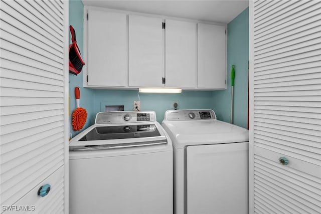 washroom with washing machine and dryer and cabinets