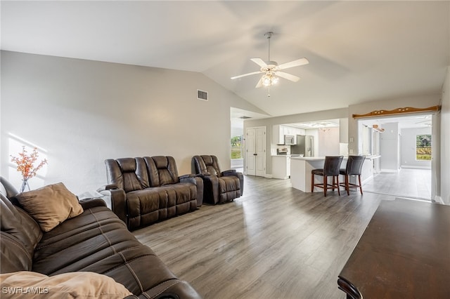 living room with hardwood / wood-style floors, ceiling fan, lofted ceiling, and a wealth of natural light