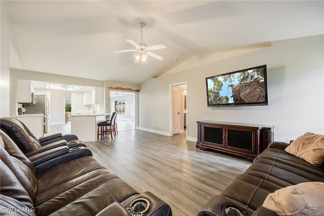 living room with light hardwood / wood-style floors, ceiling fan, lofted ceiling, and sink