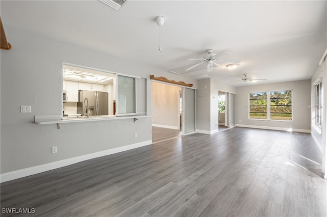 unfurnished living room featuring ceiling fan and dark wood-type flooring