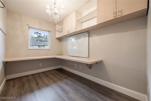 unfurnished office with an inviting chandelier and dark wood-type flooring