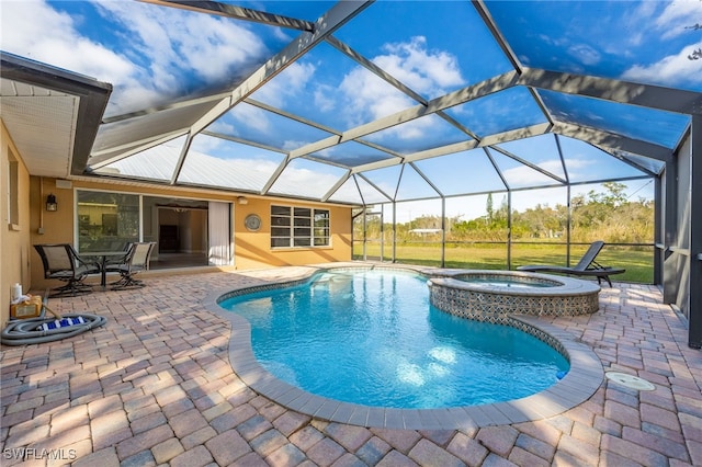 view of pool with glass enclosure, a patio area, and an in ground hot tub