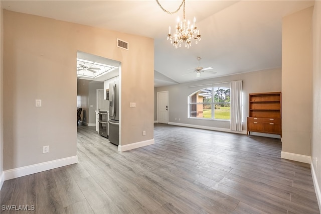 unfurnished living room featuring hardwood / wood-style floors, ceiling fan with notable chandelier, and vaulted ceiling