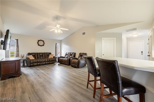 living room featuring ceiling fan, plenty of natural light, light hardwood / wood-style flooring, and vaulted ceiling