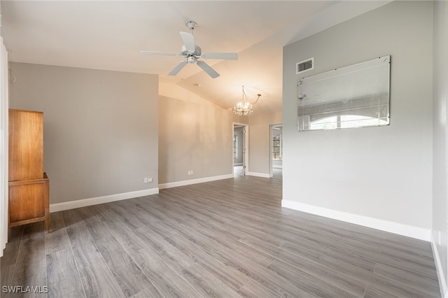 unfurnished room featuring ceiling fan with notable chandelier, wood-type flooring, and vaulted ceiling