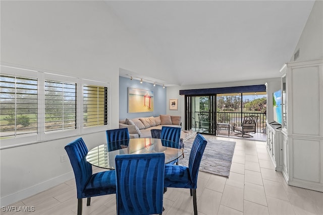 dining area with lofted ceiling and rail lighting