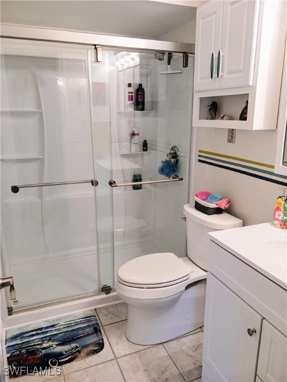 bathroom with toilet, tile patterned flooring, a shower with door, and vanity