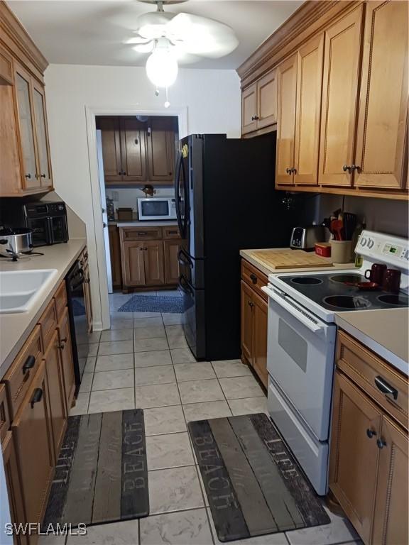 kitchen with ceiling fan, light tile patterned flooring, black appliances, and sink