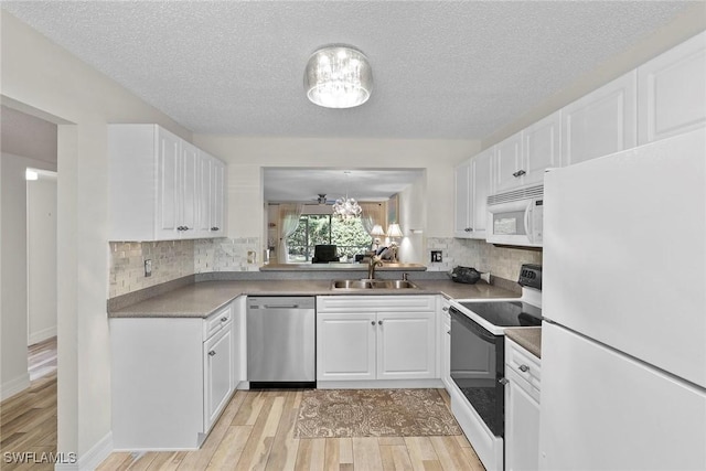 kitchen with sink, tasteful backsplash, a textured ceiling, white appliances, and white cabinets