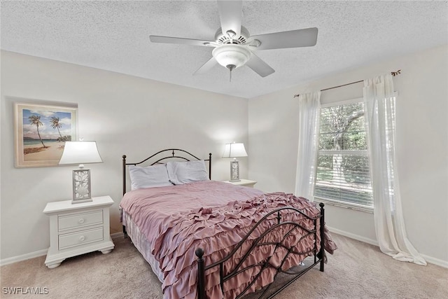 carpeted bedroom with multiple windows, ceiling fan, and a textured ceiling