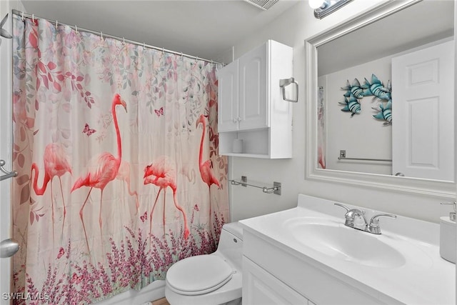 bathroom featuring vanity, curtained shower, and toilet