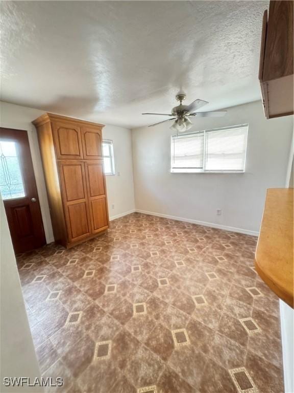 interior space with a textured ceiling and ceiling fan