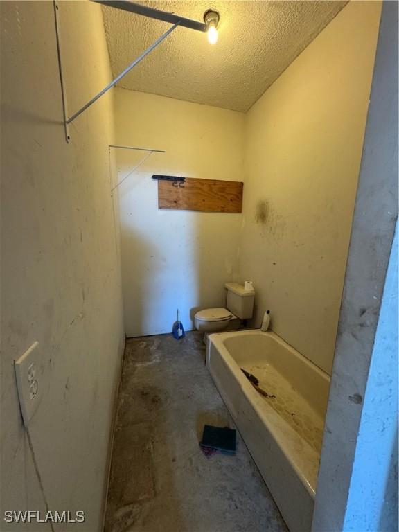 bathroom with toilet and concrete floors