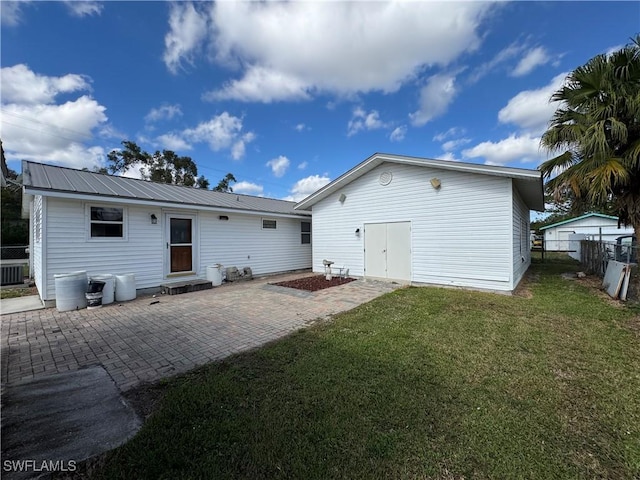 rear view of property with a patio area and a yard