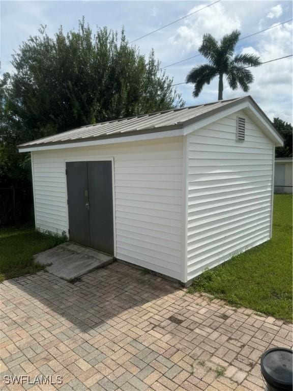 view of outdoor structure featuring a lawn