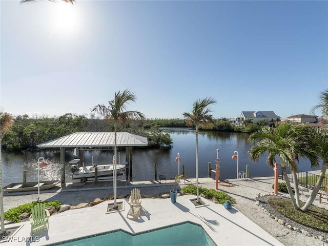 view of swimming pool featuring a patio, a water view, and a dock