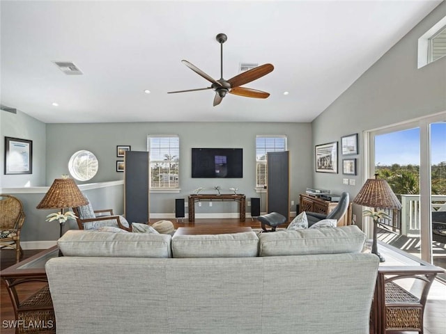 living room with ceiling fan, wood-type flooring, and vaulted ceiling