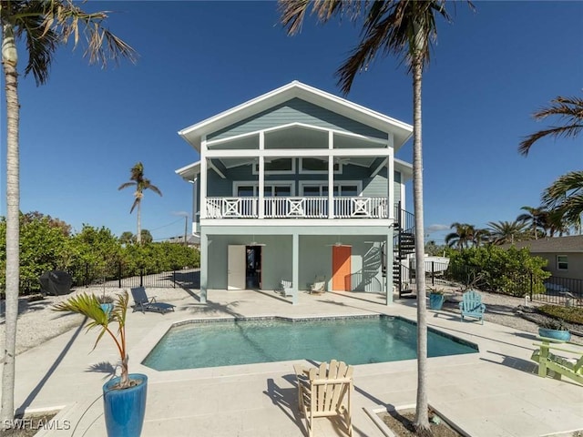 back of property with a fenced in pool and a patio