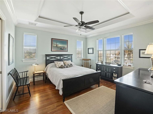 bedroom featuring multiple windows, a tray ceiling, and ceiling fan